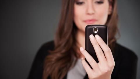 Woman looks at phone screen